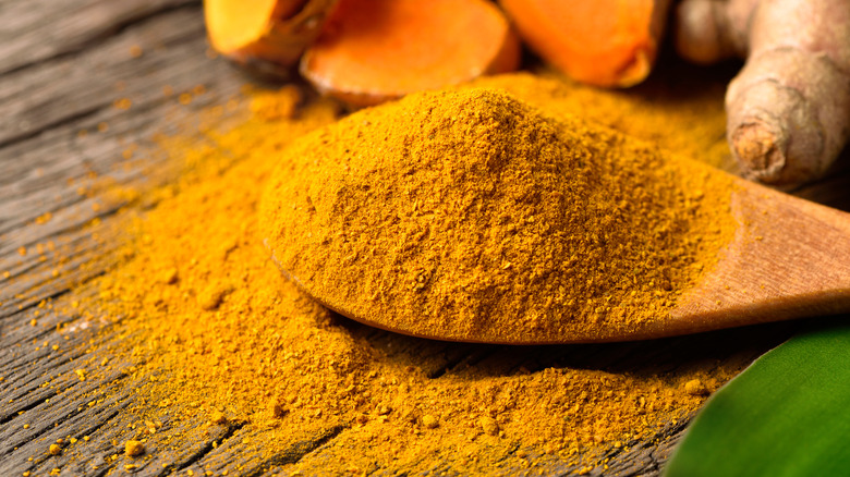 turmeric powder on wooden spoon