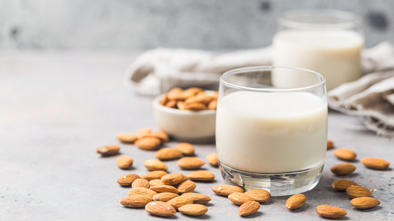 glasses of almond milk next to almonds