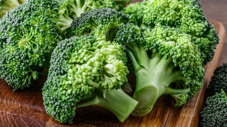 Heads of broccoli on wooden cutting board