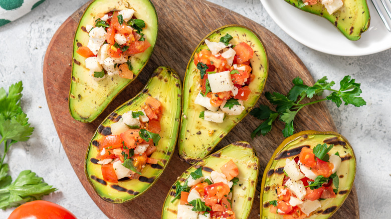 grilled avocado on wooden board