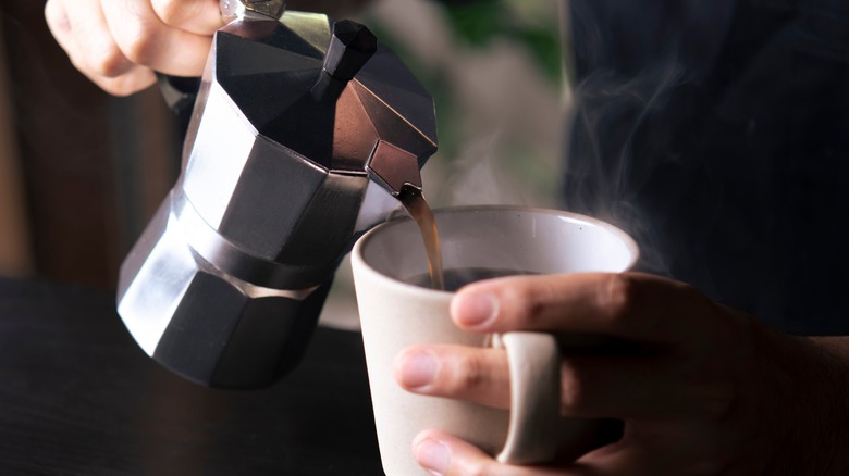 person pouring coffee into mug