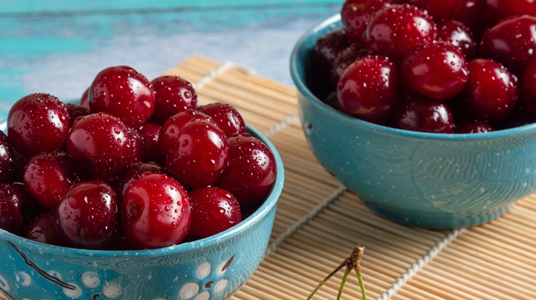 Wet cherries in two blue bowls