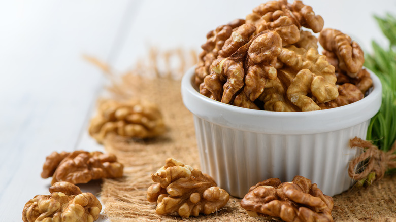 Walnuts in white cup on burlap