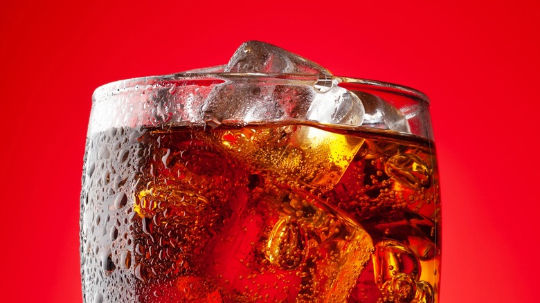 A glass of soda against a red background