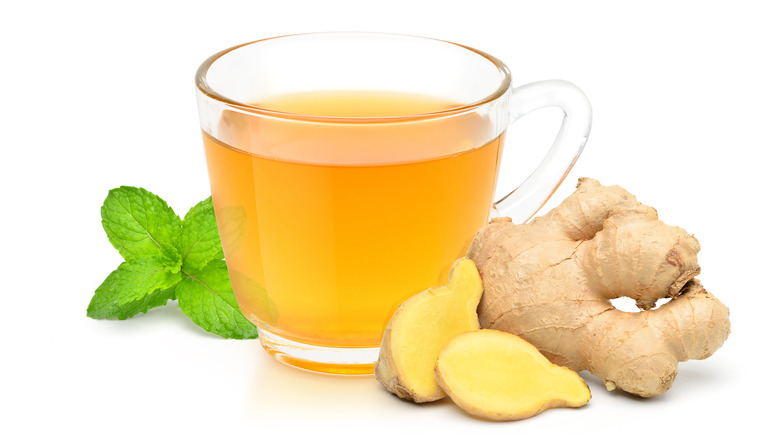 Ginger root by a cup of ginger tea