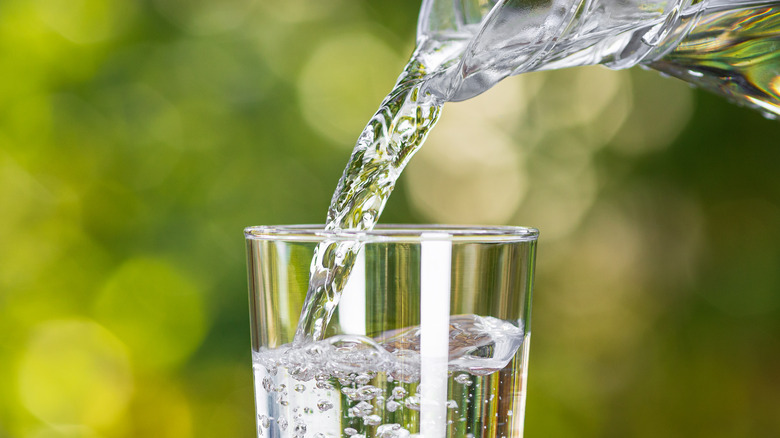 A glass of water being poured