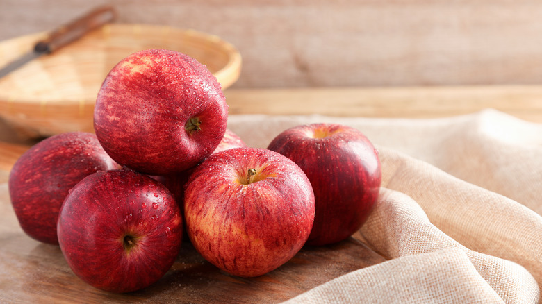 Pile of red apples on wooden surface