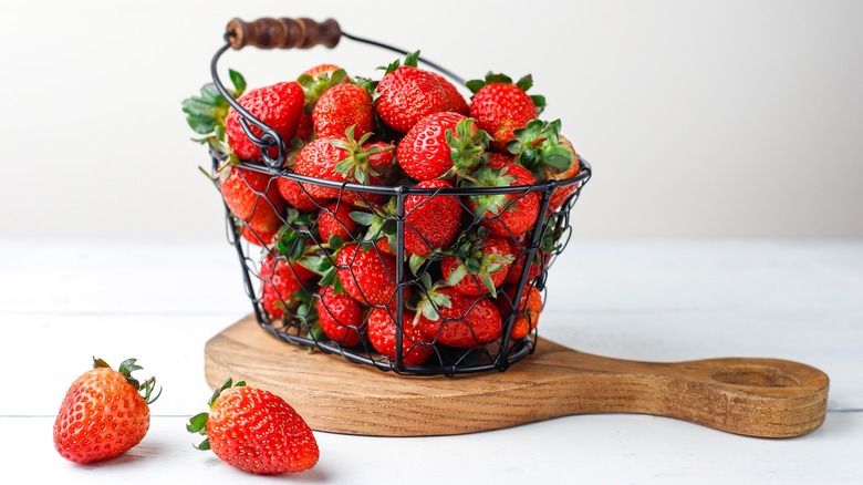 strawberries in basket on wooden board