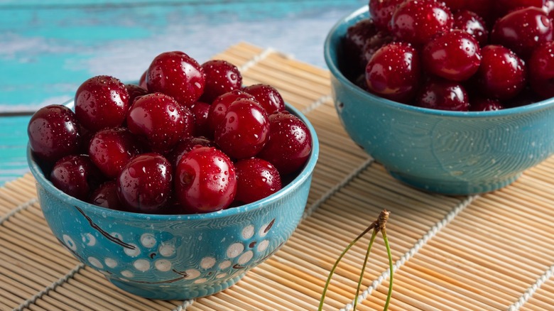 Two light blue bowls of red cherries