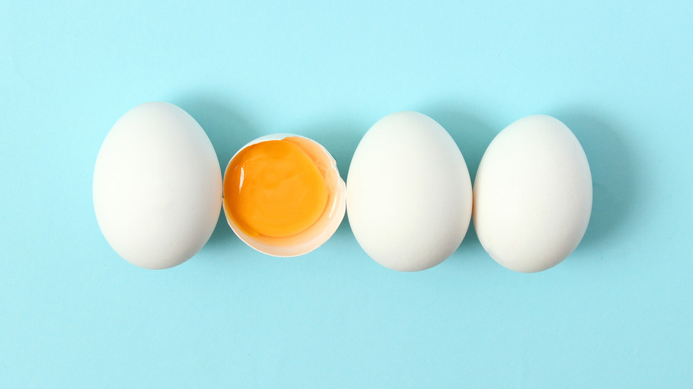 Four eggs lined up against a blue background