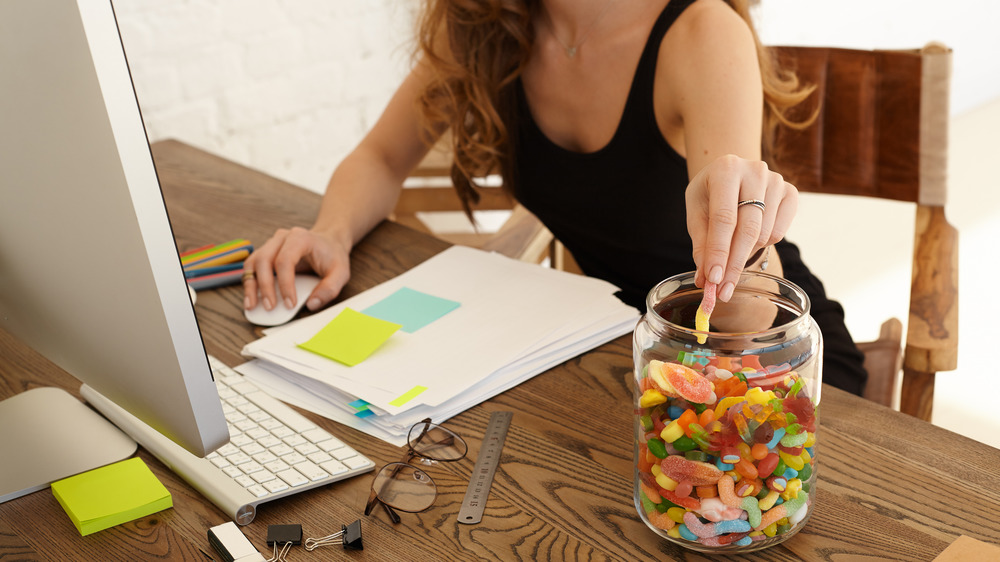 woman reaching into candy jar