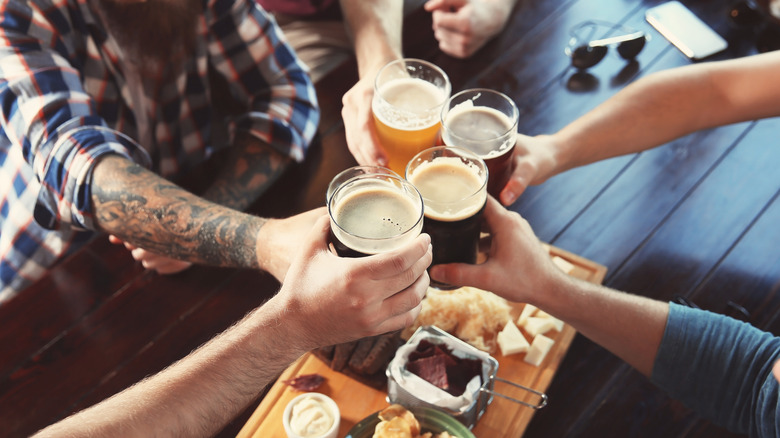 friends clinking beer glasses at a bar 