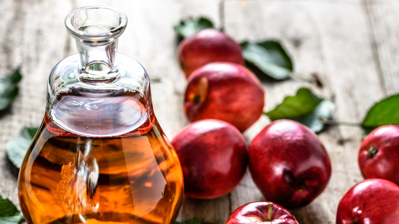 Red apples and bottle of apple cider vinegar
