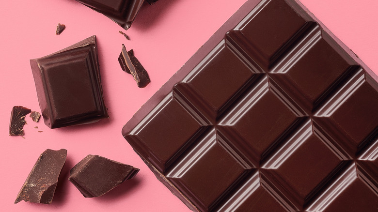 Dark chocolate against a pink background