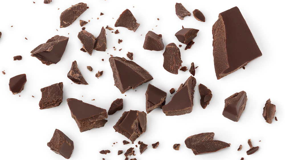 Pieces of dark chocolate scattered on white