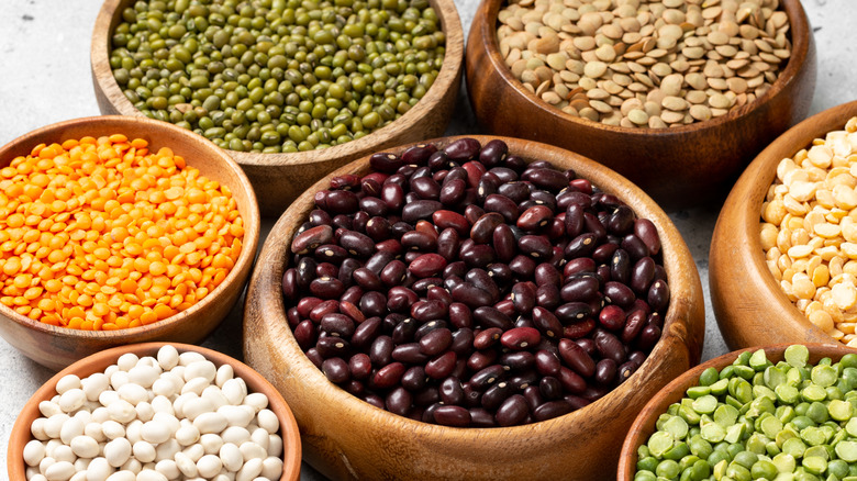 Different legumes in wooden bowls