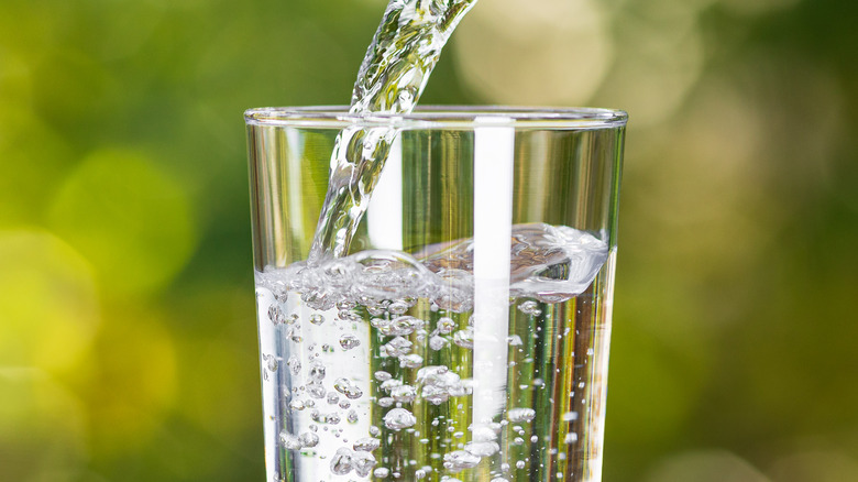 Water from jug pouring into glass