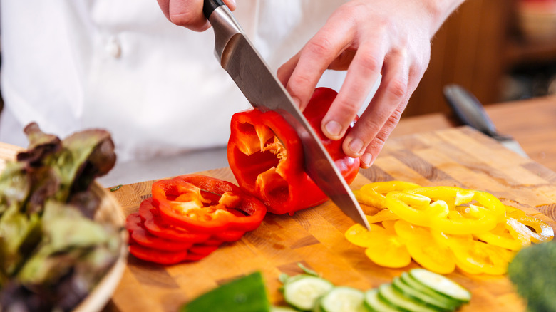 person cutting up bell peppers