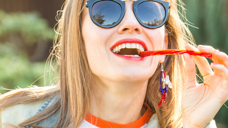 woman nibbling on red licorice