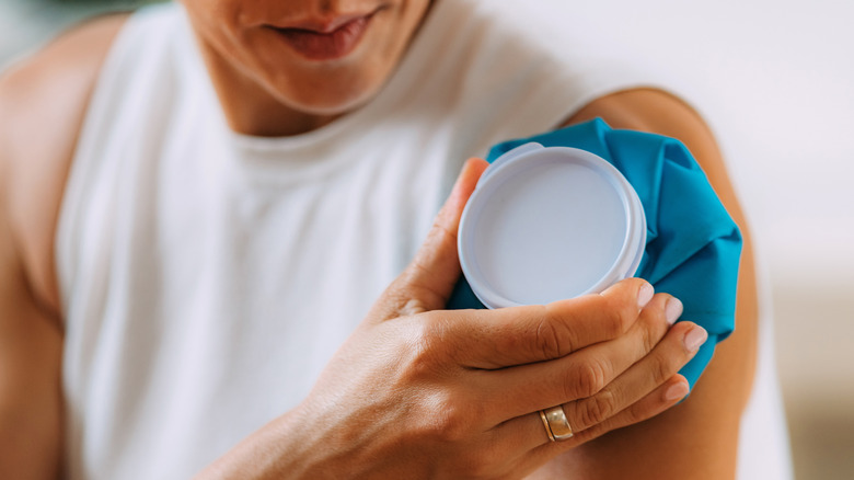 A person holding a compress to their shoulder