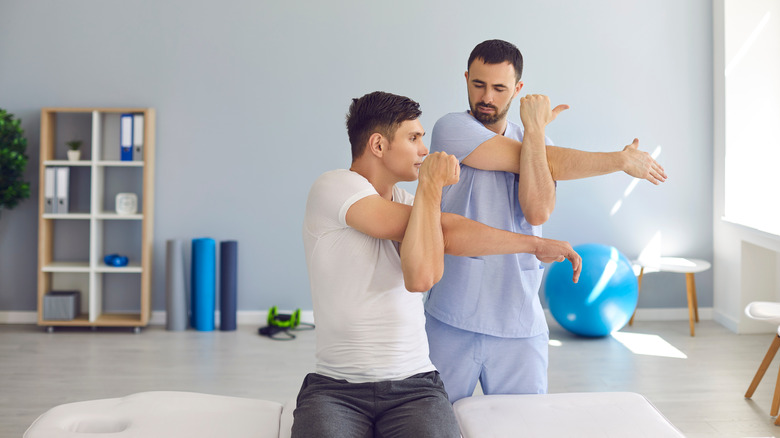 A physical therapist demonstrating an exercise to a patient