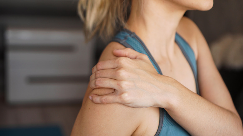 Woman holding onto her shoulder