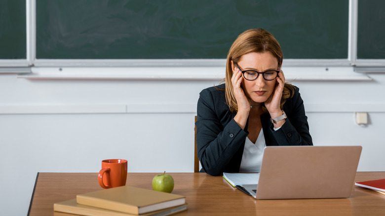 teacher with migraine at computer