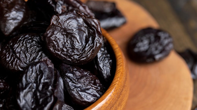 A wooden bowl of prunes