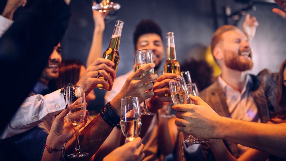 A group of friends cheers with beer and champagne