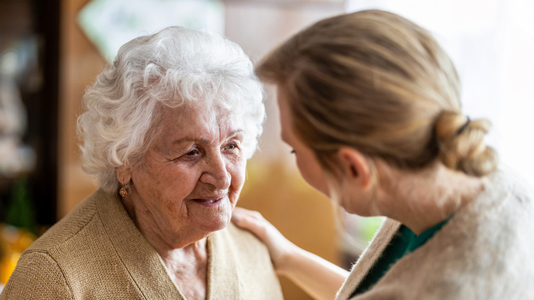 younger woman comforting elderly woman