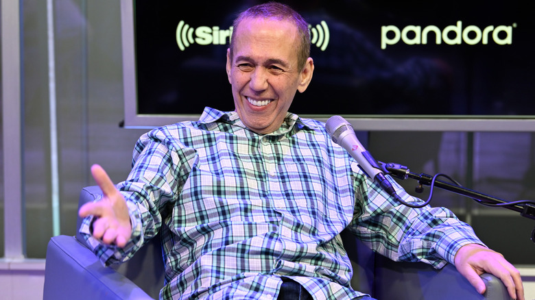 Gilbert Gottfried sitting in chair smiling