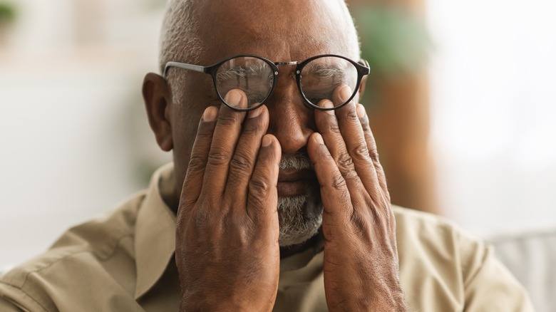 Man rubbing his eyes in pain