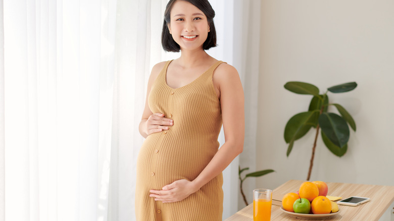 standing smiling pregnant woman 