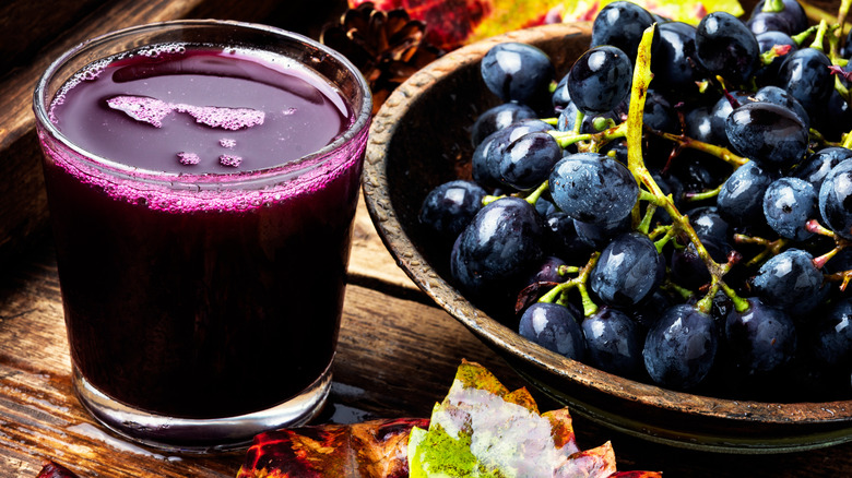 glass of grape juice next to grapes