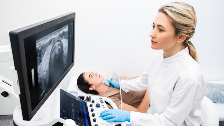 doctor performing ultrasound on thyroid 