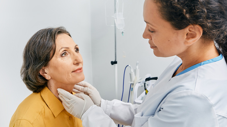 doctor performing physical examination of thyroid