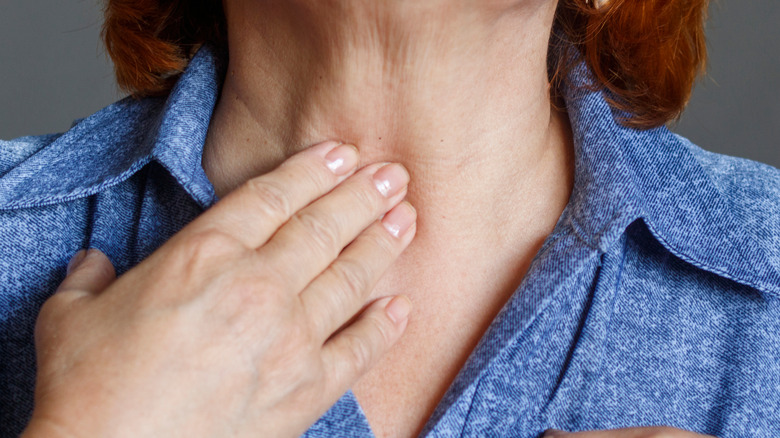 Woman touching her throat 