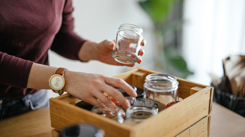 Hands sorting glass jars