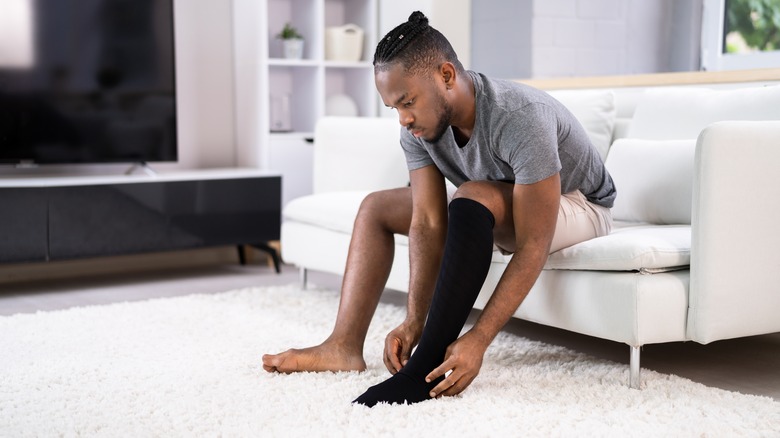 a man putting on compression stockings