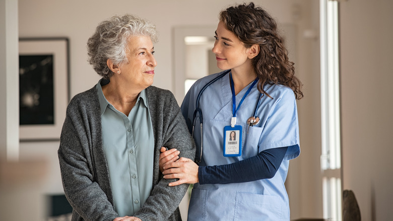 a doctor helping an elderly woman walk