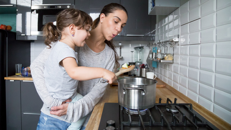 mom and daughter blowing on hot food