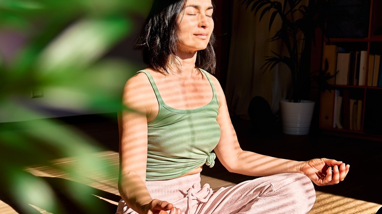 woman meditating inside home