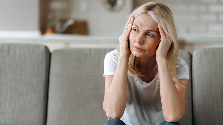 Stressed woman sitting on couch