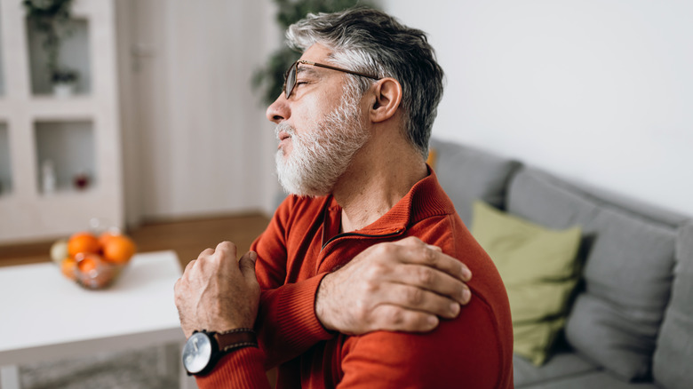 Older man stretching neck and shoulder