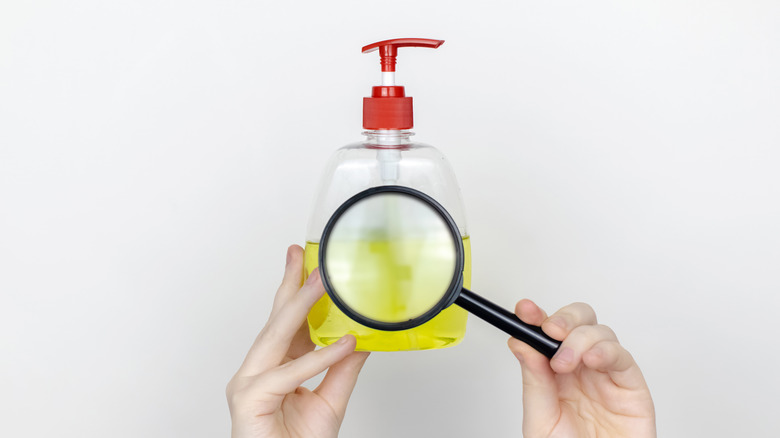 a woman examining a bottle of hand soap 