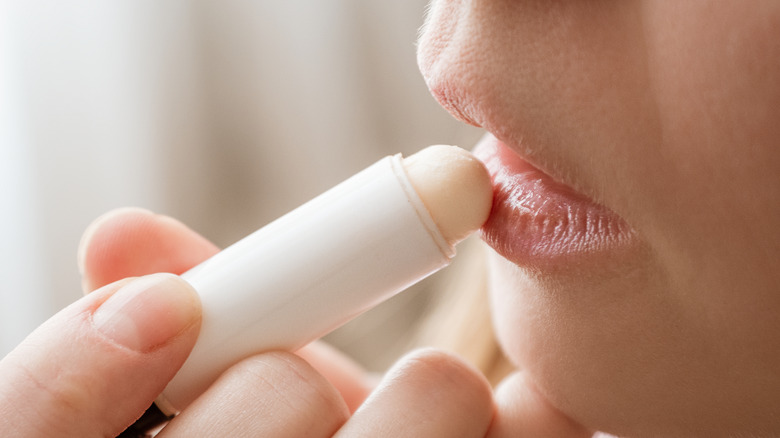 Woman applying lip balm