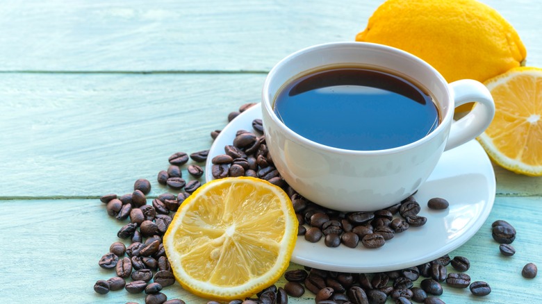 coffee mug surrounded by lemon slices and coffee beans