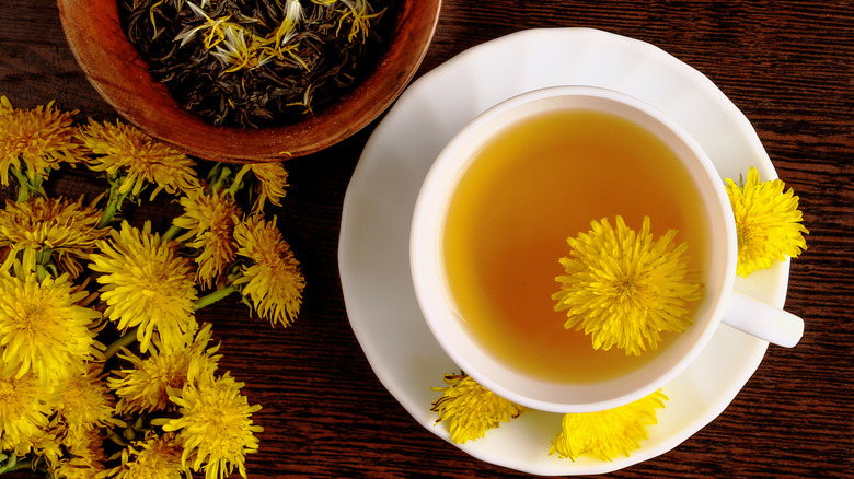 A cup of dandelion tea with a blossom in the cup