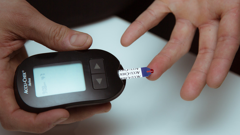 close up of finger on blood glucose monitor