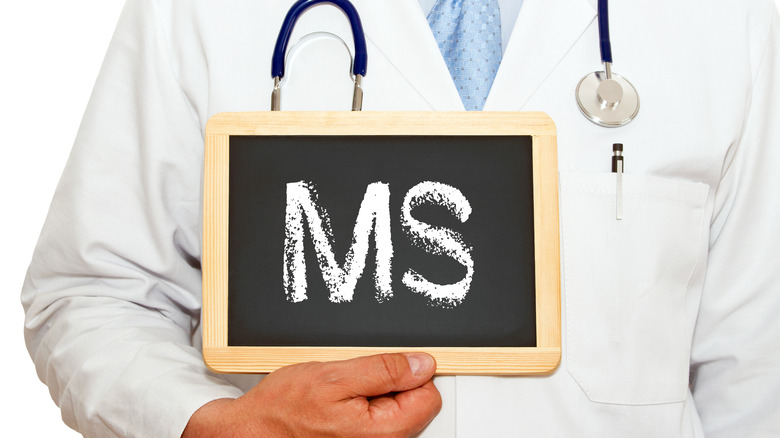 a doctor holding a chalkboard that reads ms